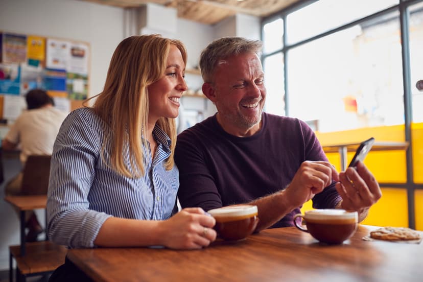 Couple sharing coffee and laughing on the couch