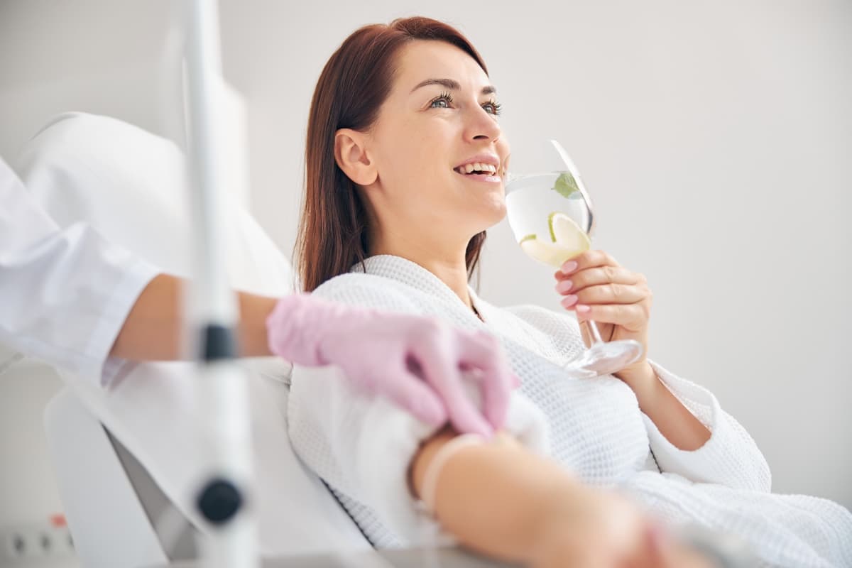 Patient smiling while receiving an IV drip at Aspire in Metairie