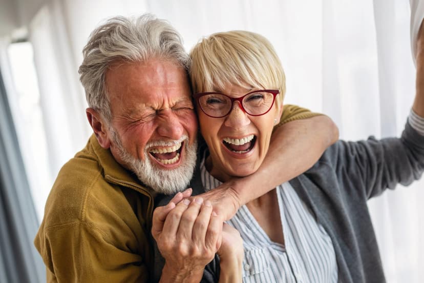 Older couple laughing together in a close hug